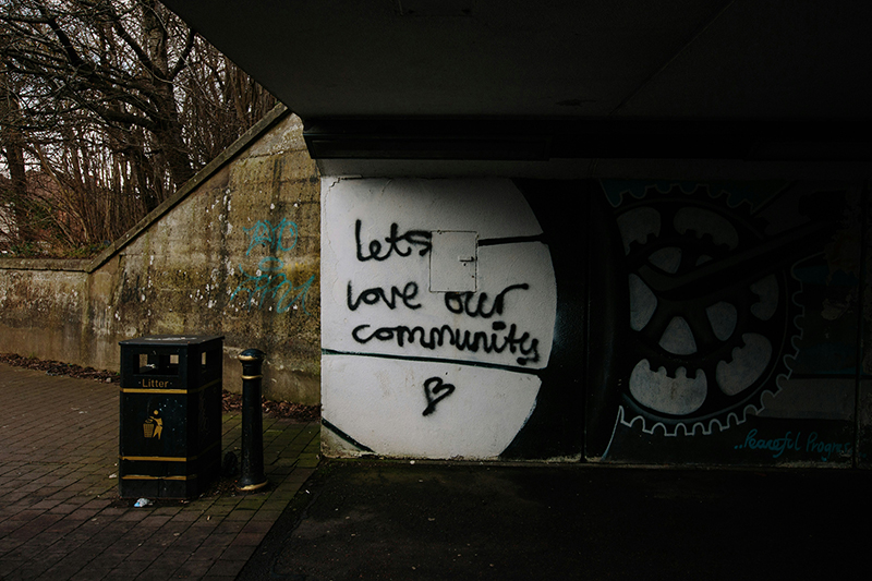 Graffiti on an underpass that reads 'let's love our community'