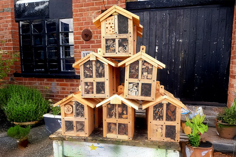 Wooden bug hotels stacked in a pyramid