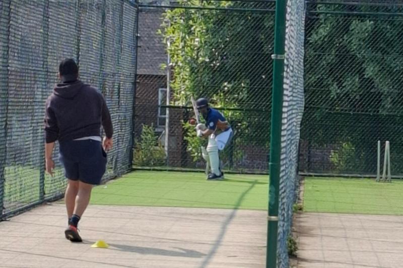 Two men playing cricket